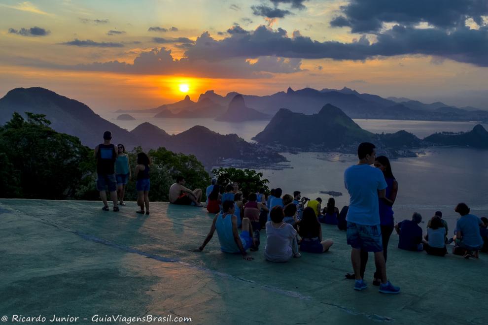 Imagem de pessoas sentados na rampa de salto vendo o por do sol no Parque da Cidade de Niteroi.